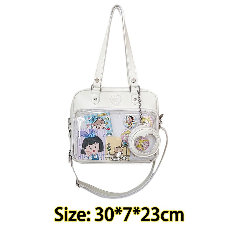 Puede incluir: Bolso tote blanco transparente de pl&aacute;stico con ribete de cuero blanco y dise&ntilde;o en forma de coraz&oacute;n. El bolso tiene un asa superior y una correa para el hombro. El bolso est&aacute; lleno de peque&ntilde;as pegatinas y pines de personajes de dibujos animados. Tama&ntilde;o: 30*7*23cm.
