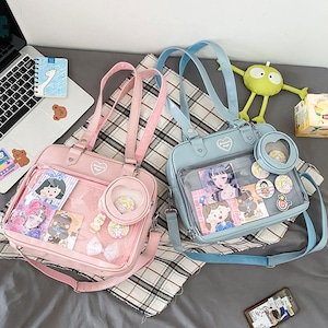 Puede incluir: Dos mochilas de pl&aacute;stico transparente con correas ajustables. Una mochila es rosa con un dise&ntilde;o de coraz&oacute;n y la otra es azul con un dise&ntilde;o de estrella. Ambas mochilas tienen personajes de dibujos animados e im&aacute;genes en su interior.
