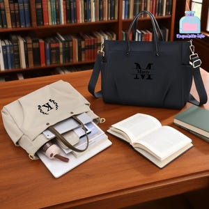 Può includere: Due borse tote, una nera e una beige, sono su un tavolo di legno con libri. La borsa nera ha una tracolla e il nome "Marry" con la lettera "M" sul davanti. La borsa beige ha la lettera "K" sul davanti.