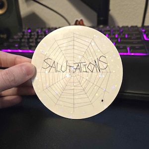 Saludos - La telaraña de Carlota - Pegatina holográfica literaria