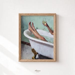 May include: A framed oil painting depicting a white claw-foot bathtub against a sage green wall. The artwork shows legs resting in the water and a hand holding a stemmed glass of white wine. The frame is ornate, textured, and gold in color.