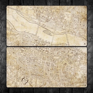 May include: Two rectangular, vintage-style map prints in sepia tones, showing a city layout with streets, buildings, and a river labelled "Miskatonic River." The maps feature a compass rose and are set against a dark wood grain background.