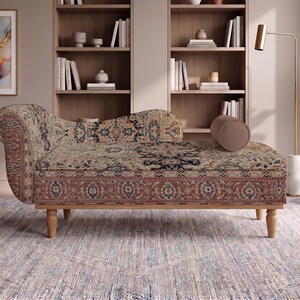May include: A chaise lounge featuring a rolled armrest and a cylindrical bolster pillow, upholstered in a beige fabric with a multi-colored intricate floral and geometric pattern. The furniture is supported by four light-toned wooden legs.
