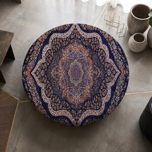 May include: A circular rug featuring a detailed, symmetrical Persian-style pattern in deep navy blue, cream, and burnt orange tones. The intricate design radiates from a central medallion, showcasing ornate floral and geometric motifs throughout.