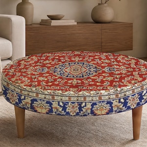 May include: A round ottoman featuring a vibrant red and blue Persian-style rug pattern with intricate floral motifs. The circular top displays a central medallion, while the side panel showcases a blue border with detailed botanical designs.