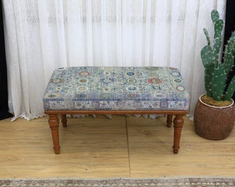 Può includere: Panca rettangolare imbottita con piano fantasia nei toni del blu, verde e rosso. La panca ha una struttura in legno e quattro gambe tornite. La panca è un elemento d'arredo decorativo.