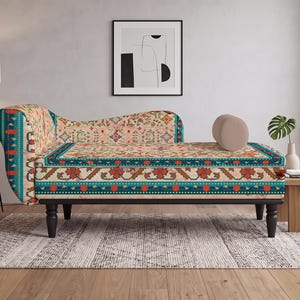 May include: A chaise lounge featuring a beige base with a multi-colored floral and geometric pattern in shades of teal, red, and orange. The furniture piece has a curved backrest, a cylindrical bolster pillow, and four black turned wooden legs.