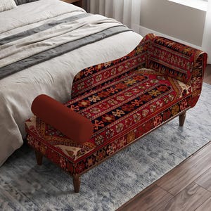May include: A rectangular bench with a backrest and a cylindrical bolster pillow, upholstered in a red, black, and gold patterned fabric featuring geometric motifs. The bench is supported by four dark brown wooden legs with a tapered design.