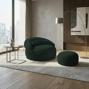 Pu&ograve; includere: Una poltrona moderna verde scuro con un pouf abbinato. La sedia ha uno schienale arrotondato e un piccolo cuscino attaccato. Il pouf &egrave; circolare. L'arredamento &egrave; in una stanza con una grande finestra, un tavolino e una lampada da terra.