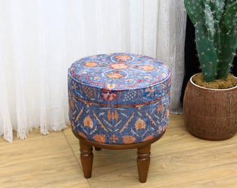 Könnte beinhalten: Ein runder blauer und orangefarbener Hocker mit Holzbeinen. Der Hocker steht auf einem Holzboden.