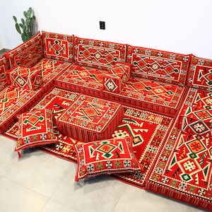 May include: A red and green patterned floor cushion set with intricate designs. The set includes multiple cushions of varying sizes and shapes, perfect for creating a comfortable and stylish seating area.