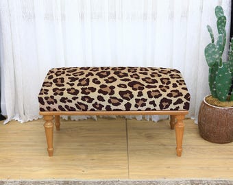 Brązowo-brązowa, prostokątna, tapicerowana ławka z nadrukiem w panterkę i nogami z jasnego drewna, idealna do wystroju wnętrz w stylu safari z wyrazistym zwierzęcym nadrukiem, miękka ławka
