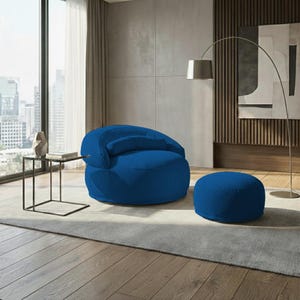 Pu&ograve; includere: Una poltrona blu in velluto a coste con un pouf abbinato. La poltrona ha lo schienale arrotondato e un piccolo cuscino attaccato. Il pouf &egrave; circolare. L'arredamento &egrave; in un salotto moderno.