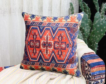 May include: A decorative throw pillow with a red, blue, and white geometric pattern. The pillow is made of a soft, plush fabric and has a square shape.