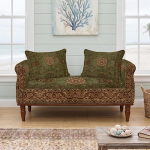 Könnte beinhalten: Ein Zweisitzer-Sofa mit dunkelgrünem Stoffbezug und einem sich wiederholenden braun-beigen Blumenmedaillonmuster. Das Möbelstück hat einen Holzrahmen mit gedrechselten Beinen und zwei passende quadratische Kissen mit demselben Muster.