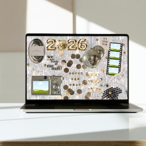May include: A laptop screen shows a New Year's collage with gold foil balloons forming "2026". The display includes disco balls, confetti, and the text "we are made of star stuff". A digital camera and film strip are also visible.
