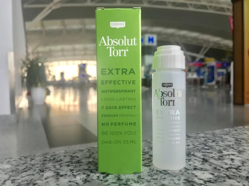 Op de afbeelding: Een groen-witte doos met de tekst "Absolut Torr Extra Effectief Antitranspirant Langdurig 7 Dagen Effect Zweeds Origineel Geen Parfum Wees 100% Jij! Dab-on 35 ml" en een doorzichtige fles met de tekst "Absolut Torr Extra Effectief Antitranspirant Langdurig 7 Dagen Effect Geen Parfum 35 ml".