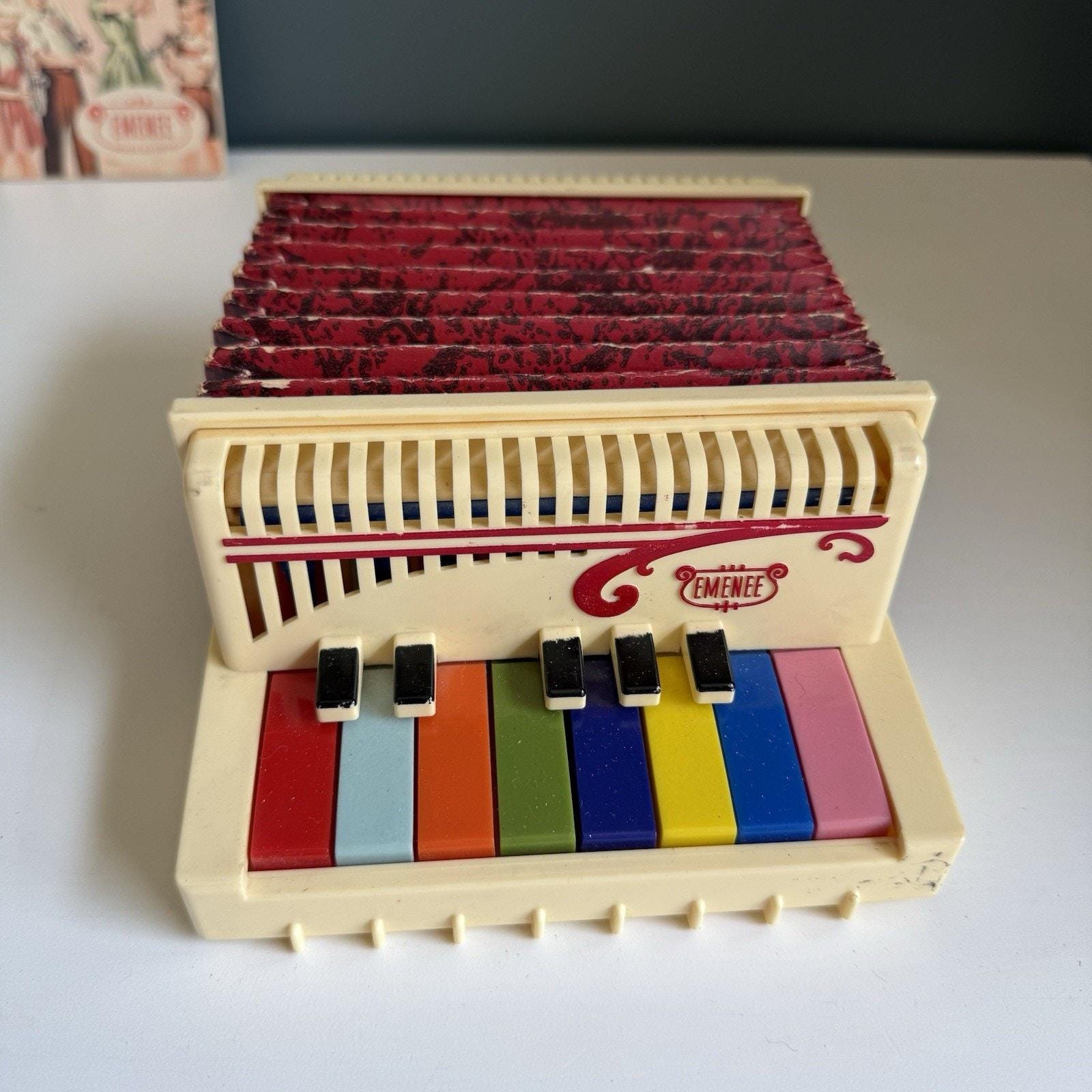 Acordeón de piano vintage Emenee de color, raro, con cancionero
