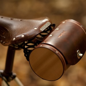 Dark brown leather barrel bicycle bag mounted on Brooks bike seat