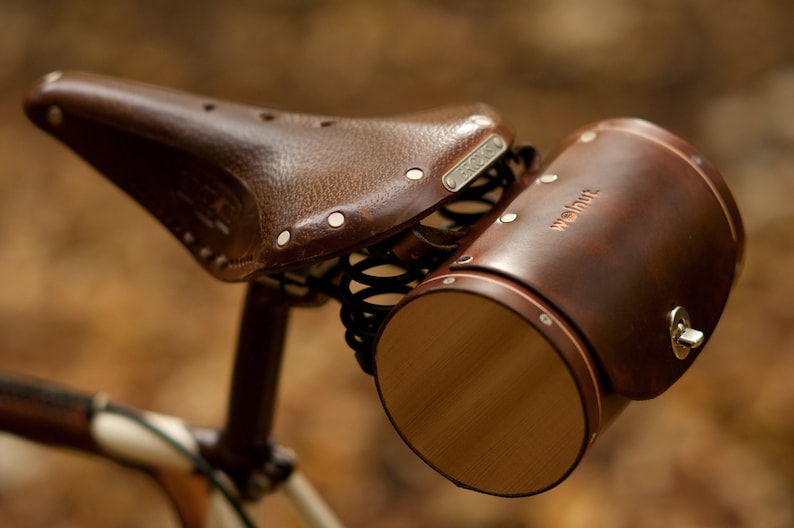 Dark brown leather barrel bicycle bag mounted on Brooks bike seat