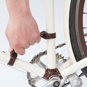 Hand demonstrating how to lift bike frame handle