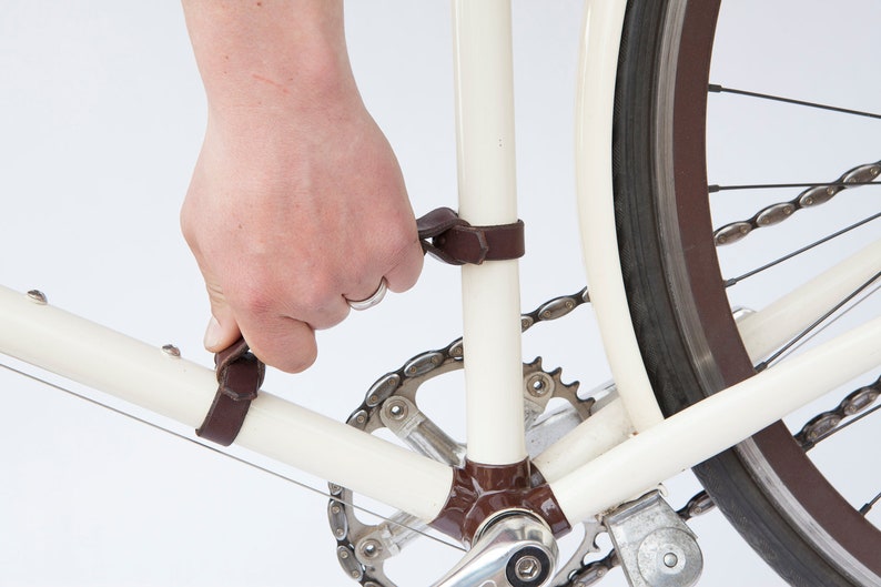 Hand demonstrating how to lift bike frame handle