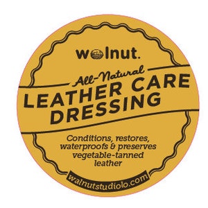 May include: A yellow round label with the text "woInut. All-Natural LEATHER CARE DRESSING" and the website "walnutstudiolo.com".