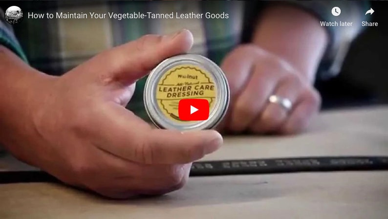 May include: A small tin container of walnut leather care dressing. The tin is yellow with black text that reads "Walnut All Natural Leather Care Dressing".