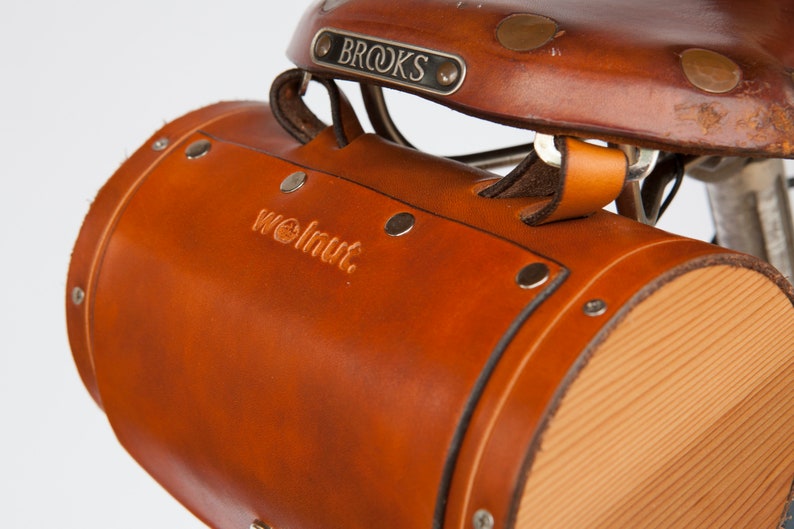 Close-up of honey leather barrel bag attached to seat tabs on Brooks saddle