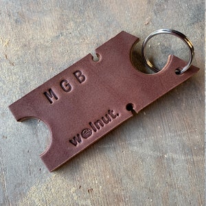 Dark brown leather headphone holder with "MGB" monogrammed