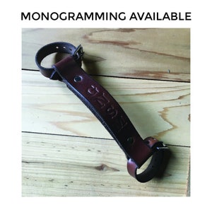 Dark brown leather bike handle on wooden table with debossing "GNSM" under text that reads "Monogramming Available"