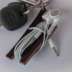 Black leather earbud cord organizer attached to carabiner