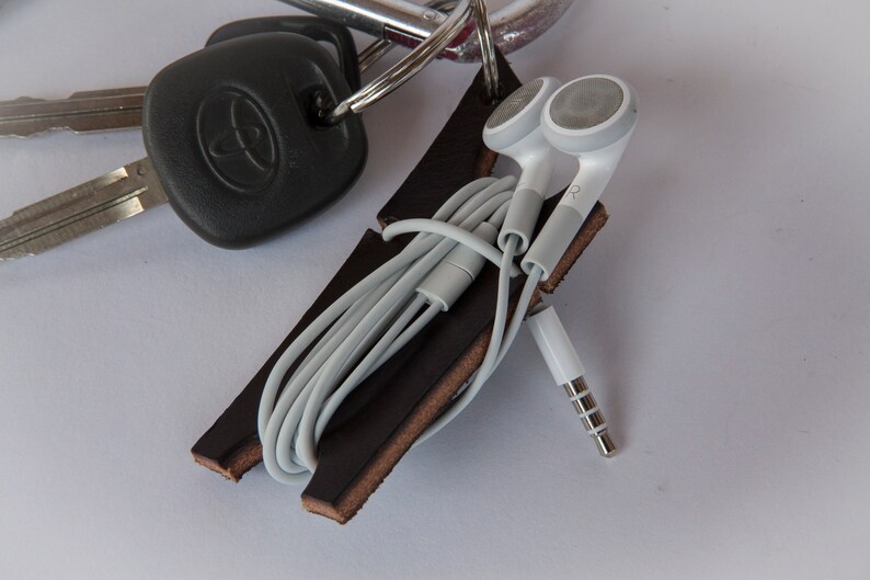 Black leather earbud cord organizer attached to carabiner