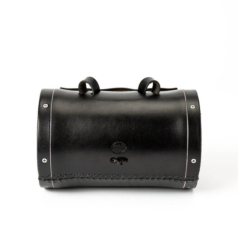 Back side of black leather barrel bag shows 3 points of connection to bicycle with silver-look hardware