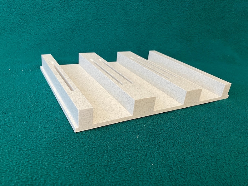 3D printed filament spool holder base with three slots, shown without filament spools to highlight the base design.