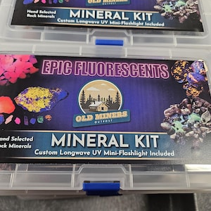 May include: A clear plastic storage box with a blue latch. The box contains a collection of rocks and minerals labeled "EPIC FLUORESCENTS" and "MINERAL KIT". The label also includes the text "Hand Selected Rock Minerals" and "Custom Longwave UV Mini-Flashlight Included".