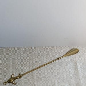 Vintage Long, Brass Shoehorn with Loop on the handle.Long, durable with two hooks for easy putting on shoes.Made in Germany.Mid-Last century