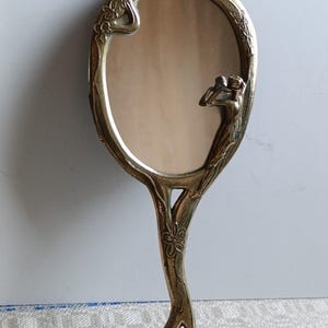 Vintage Brass,Hand Mirror for Dressing table.Mid-last century.Charm is added by a Girl looking into this mirror and allowing a hairstyle.50s
