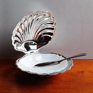 Könnte beinhalten: Ein Set aus drei Keramikbechern mit gesprenkelter, matter Oberfläche. Die Becher sind in Creme-, Hellbraun- und Dunkelbrauntönen gehalten. Jeder Becher hat ein schlichtes, minimalistisches Design und einen abgerundeten Griff.