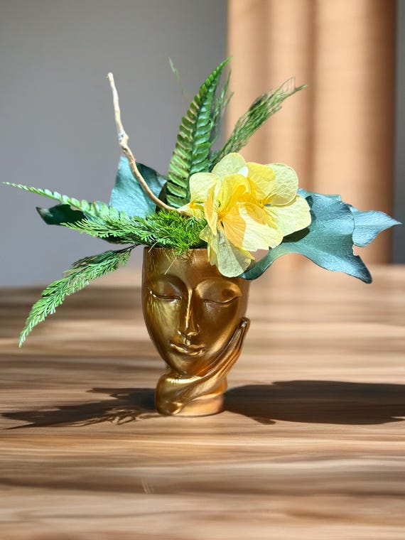 Vase visage doré avec composition végétale stabilisée – décoration poétique et design, centre de table ou console