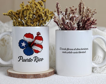 May include: Two white ceramic mugs with handles, each holding dried flowers. One mug features a Puerto Rican flag hibiscus flower design and the text "Puerto Rico." The other mug has Spanish text.