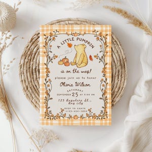 May include: A rectangular invitation card featuring a yellow bear illustration, orange pumpkins, and autumn leaves. The text reads A LITTLE PUMPKIN is on the way! please join us to honor Olivia Wilson SATURDAY SEPTEMBER 25 AT 6:00 PM 123 Anywhere St., Any city.