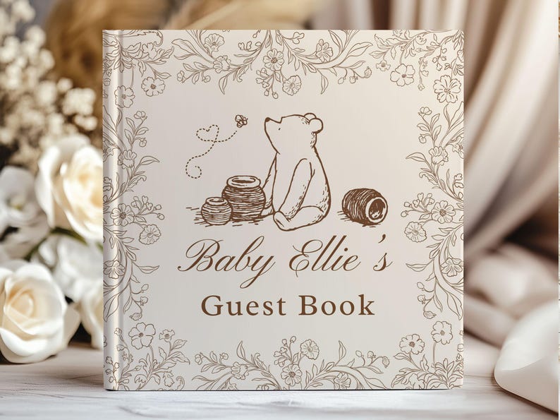 May include: A square guest book with a cream-colored cover featuring a brown line-art illustration of a bear sitting near honey pots, surrounded by a floral border. The text reads Baby Ellie's Guest Book in a brown serif and script font.