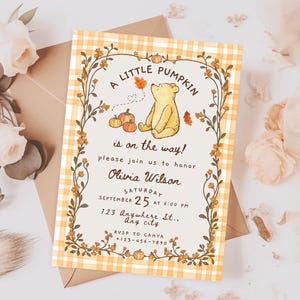 May include: A rectangular baby shower invitation card featuring a yellow and white gingham border, a central illustration of a yellow bear with pumpkins, and text reading A LITTLE PUMPKIN is on the way! honoring Olivia Wilson on September 25.