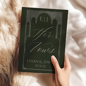 May include: A dark green wedding vow book with the words "Her Vows" in elegant script. The book features the initials "E|J" at the top and the names "Ethan & Jenn" with the date "10.31.25" at the bottom. The cover has an ornate, silver-colored border.