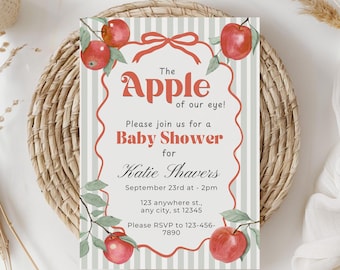 May include: A baby shower invitation with a red apple theme. The invitation features the text "The Apple of our eye!" and details for Katie Shavers' baby shower, including the date, time, and RSVP information. The design includes red apples and green leaves.