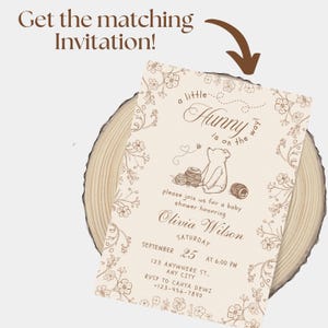May include: A rectangular baby shower invitation card featuring brown line art of a bear, honey pots, and floral borders on a cream background. The text reads: Get the matching Invitation! a little Hunny is on the way! please join us for a baby shower honoring Olivia Wilson SATURDAY SEPTEMBER 25 AT 6:00 PM 123 ANYWHERE ST. ANY CITY RSVP TO CAHYA DEWI +123-456-7890.