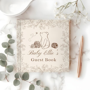 May include: A square guest book with a cream cover featuring a brown line-art illustration of a bear, honey pots, and floral borders. The text reads Baby Ellie's Guest Book in a brown script and serif font, centered on the front cover.
