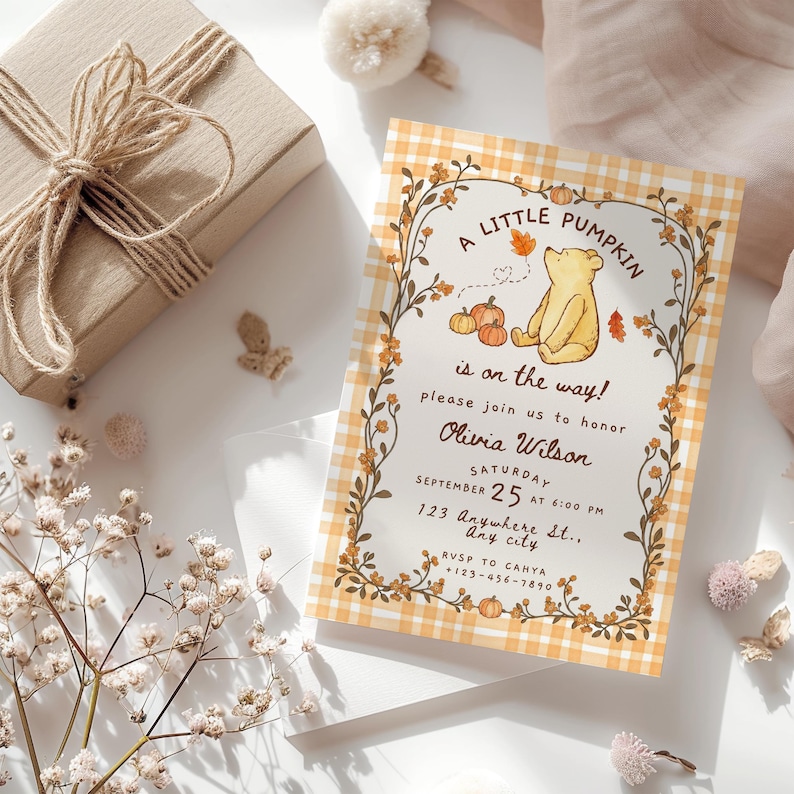 May include: A rectangular invitation card featuring a yellow and white gingham border, a central illustration of a bear, pumpkins, and autumn leaves, with the text A LITTLE PUMPKIN is on the way! please join us to honor Olivia Wilson SATURDAY SEPTEMBER 25 AT 6:00 PM 123 Anywhere St., Any city RVSP TO CAHYA +123-456-7890.