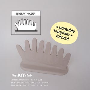 Op de afbeelding: Een lichtbeige keramische sieradenhouder met een handvormig ontwerp. De houder heeft een platte basis en zeven vingerachtige uitsteeksels om ringen en andere sieraden vast te houden. Tekst op de afbeelding luidt "Jewelry Holder" en "a printable template + tutorial."